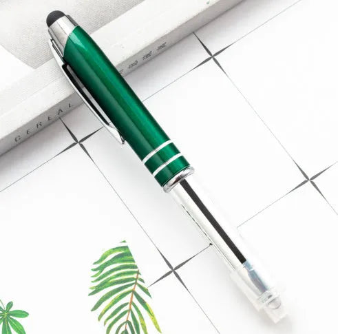 Red metal multifunctional stylus ballpoint pen with LED light on a desk.