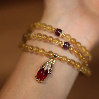 Natural gold rutilated quartz bracelet with Chinese style three circles and hanging chopsticks design.