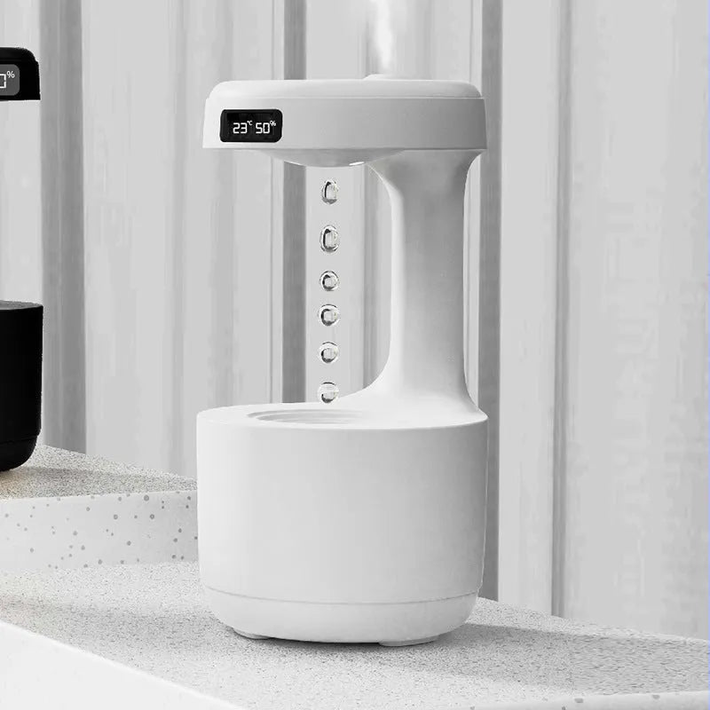 White columnar anti-gravity humidifier with water droplet backflow and LED clock display on a desk.