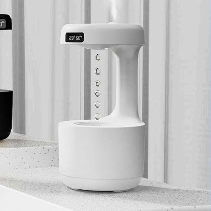 White columnar anti-gravity humidifier with water droplet backflow and LED clock display on a desk.