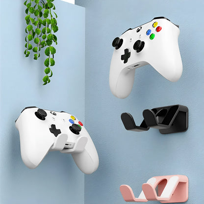 Black ABS plastic universal wall hanging rack for game controllers with adhesive pad and screws.