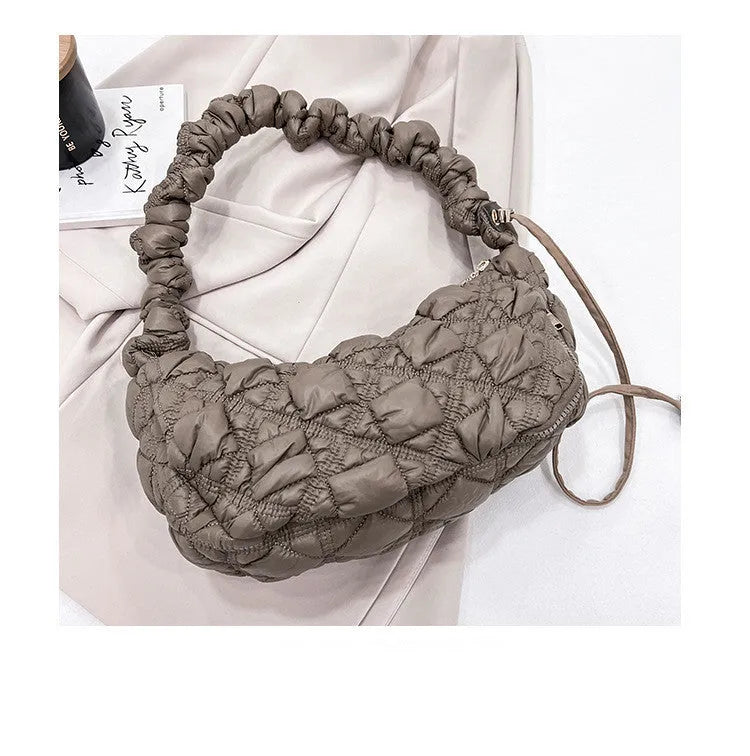 Women's light grey nylon underarm messenger bag with adjustable long strap, shown worn crossbody.
