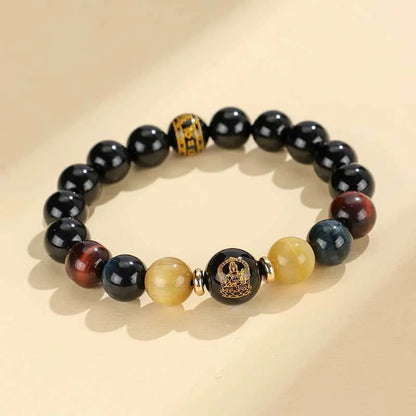 Handcrafted black agate and tiger eye stone beaded bracelet with a central carved zodiac deity charm.