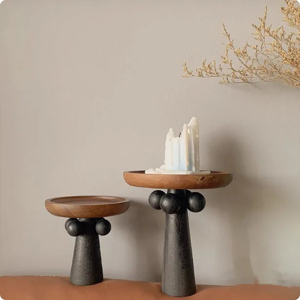 Round beech wood tray with high legs for candles and aromatherapy accessories on wooden table
