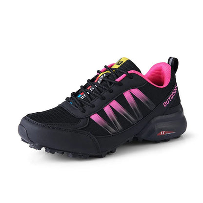 Men's black mountaineering sneakers with a rubber sole and lace-up front on a rocky surface.