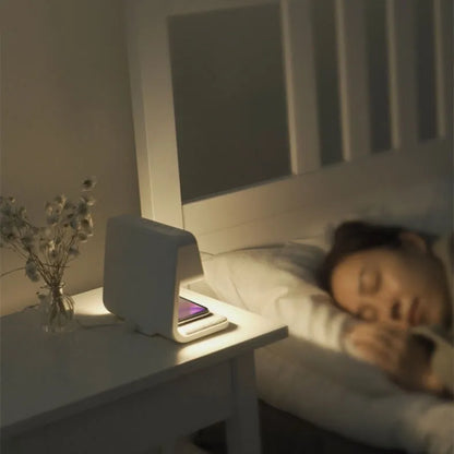White 3-in-1 bedside lamp with wireless charging pad, LCD alarm clock screen, and touch controls.