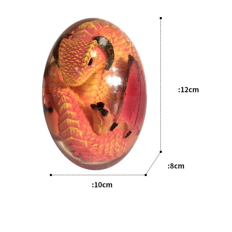 A lifelike resin dragon egg ornament with a crystal-clear, transparent design, sitting on a glowing lava-style base.