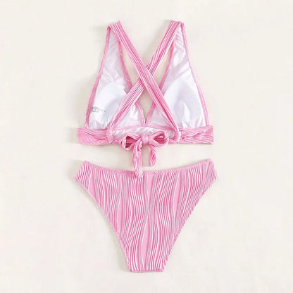 Pink and black women's halter strap bikini with split shorts on a white background