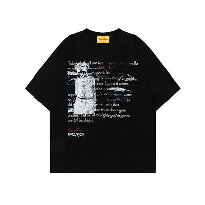 Man wearing a black loose-fit cotton t-shirt with a letter print and raglan sleeves.