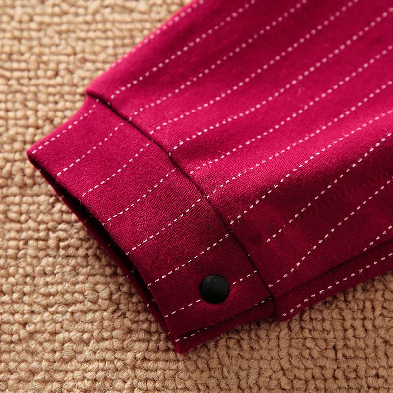 Wine red long sleeve cotton romper for a baby boy on a hanger.