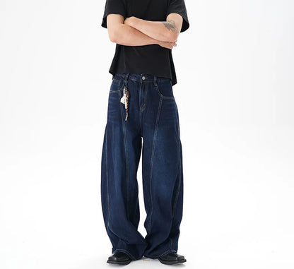 Dark blue distressed wide leg Machete jeans laid flat, showing washed denim texture.