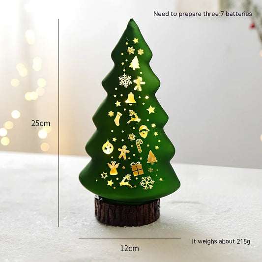 Luminous green Christmas tree glass decoration, 12 cm tall, glowing on wooden desk with soft LED light