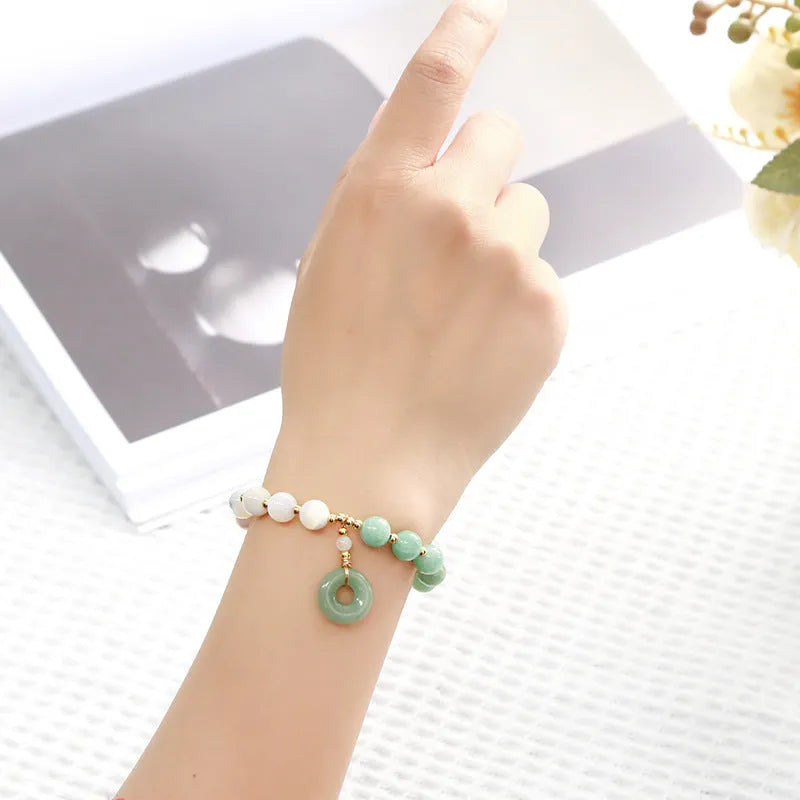 Blue Burma jade bead bracelet with copper horseshoe screw safety buckle on a wrist.