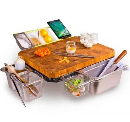 Bamboo cutting board with smooth surface alongside two large and three small plastic storage trays for vegetables and meat.