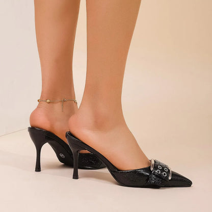 Black women's high heels with pointed toe, ankle strap, and decorative buckle.