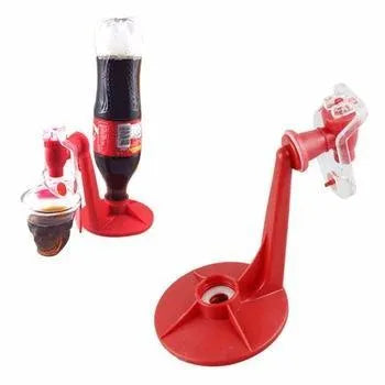 Red plastic Magic Tap soda bottle dispenser attached to an inverted 2-litre bottle on a kitchen table.