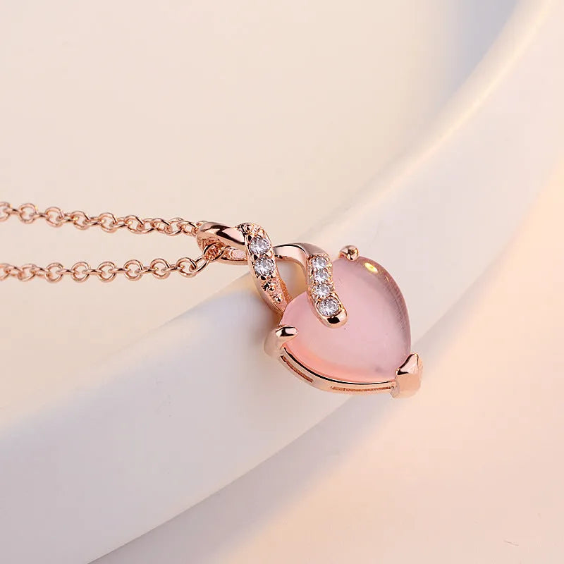 Women's rose gold heart-shaped pendant necklace with pink crystal centre on cross chain