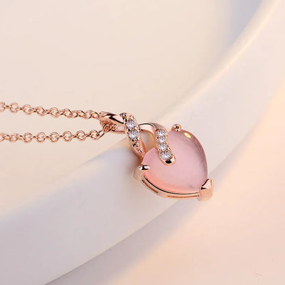 Women's rose gold heart-shaped pendant necklace with pink crystal centre on cross chain