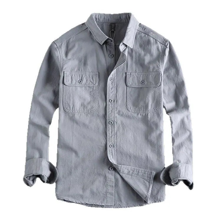 Man wearing a loose-fit grey cardigan-style overalls shirt with long sleeves.