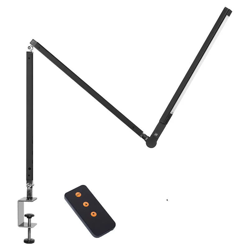 Adjustable aluminium desk lamp with remote control, shown in black with a clip attached to a desk edge.