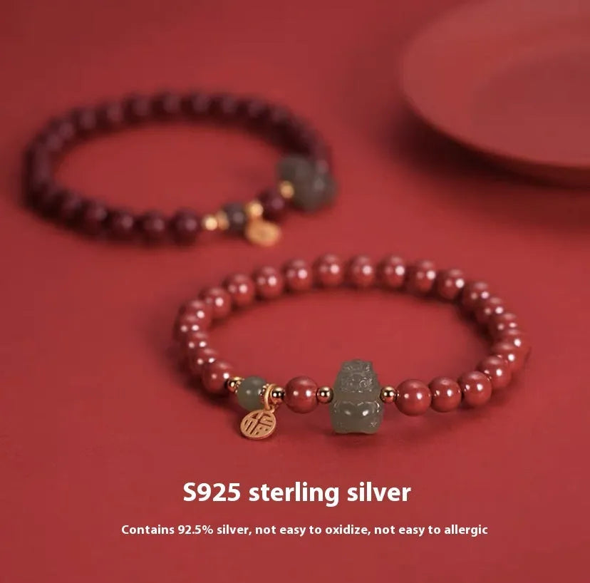 Natural Hetian jade bracelet with zodiac carvings and cinnabar accents in 8mm diameter