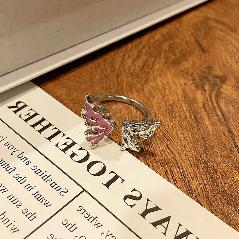 Copper butterfly women's ring with an open loop design on a plain background.