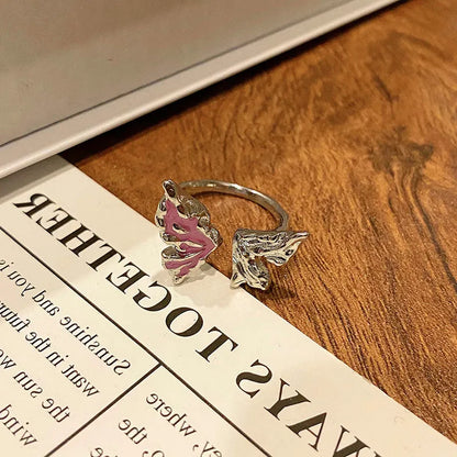 Copper butterfly women's ring with an open loop design on a plain background.