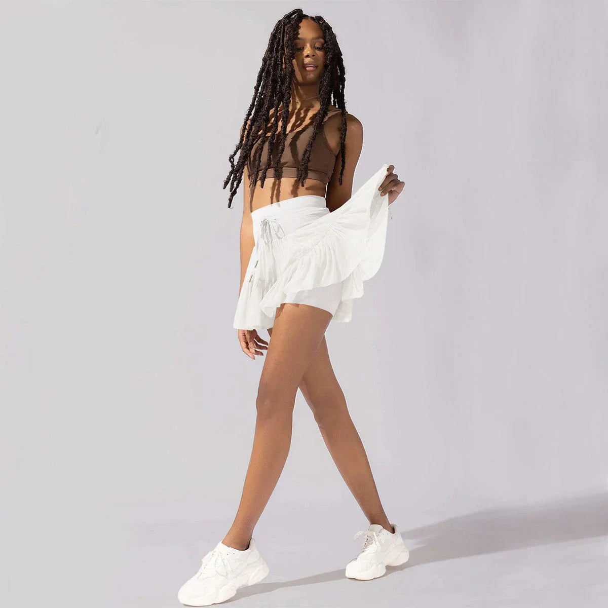 Stylish high-waist pleated skirt with lace-up accents in various colors, including black, gray, blue, apricot, pink, white, and purple