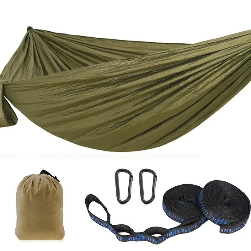 Parachute cloth double camping hammock in chosen colour, with black buckles and round ropes on a tree.