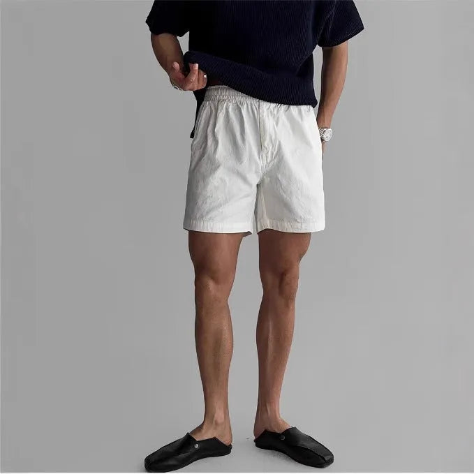Cotton loose-fit sports shorts in black, shown on a hanger.
