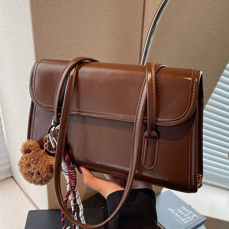 Brown women's square shoulder bag with double straps and pendant accessory