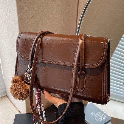 Brown women's square shoulder bag with double straps and pendant accessory
