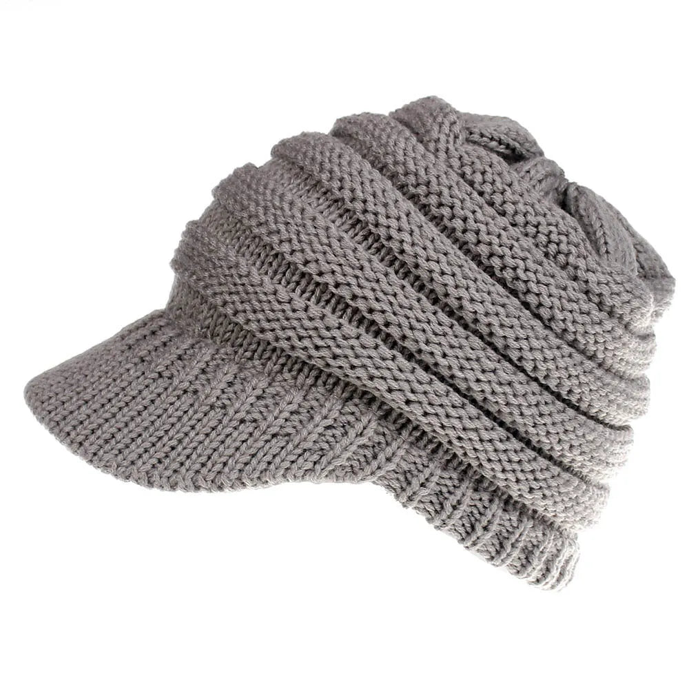 Women's acrylic knitted ponytail beanie in a solid colour, shown on a model with a ponytail.