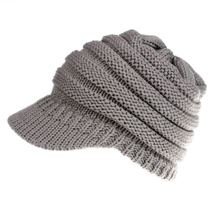 Women's acrylic knitted ponytail beanie in a solid colour, shown on a model with a ponytail.