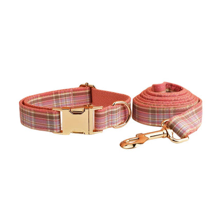 Red plaid cloth dog collar and leash set with matching bow on a white background