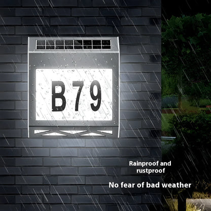 Black solar doorplate light with LED illumination showing house numbers