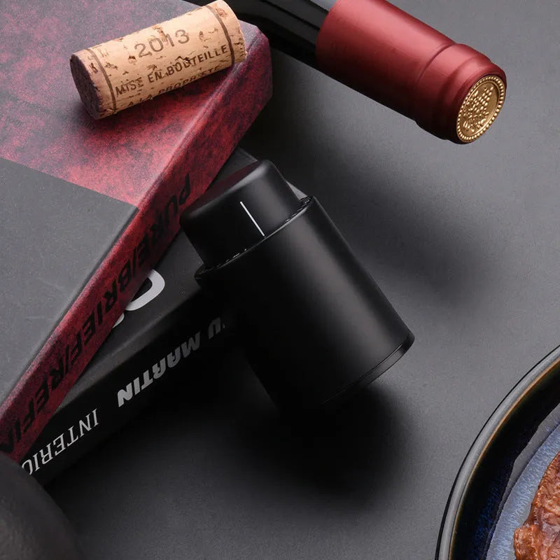 Black electric wine opener with transparent cover and aluminum foil cutter on wooden table