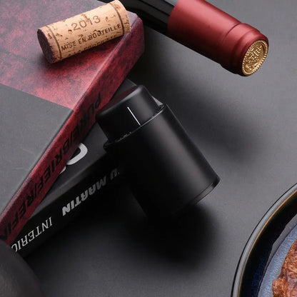 Black electric wine opener with transparent cover and aluminum foil cutter on wooden table