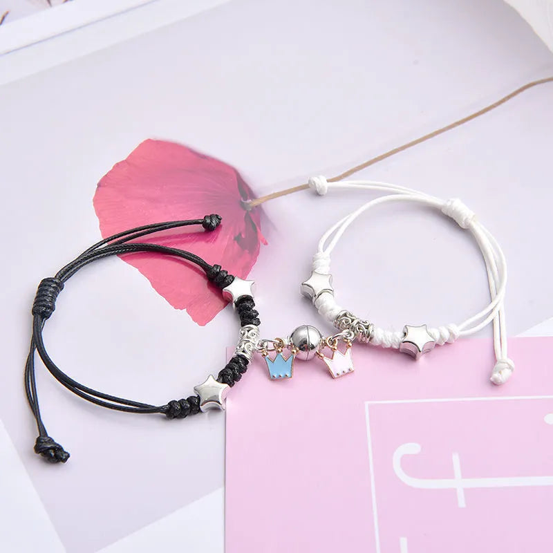 A pair of magnet couple bracelets with a suction clasp, showing various design options like clovers, crowns, and hearts.