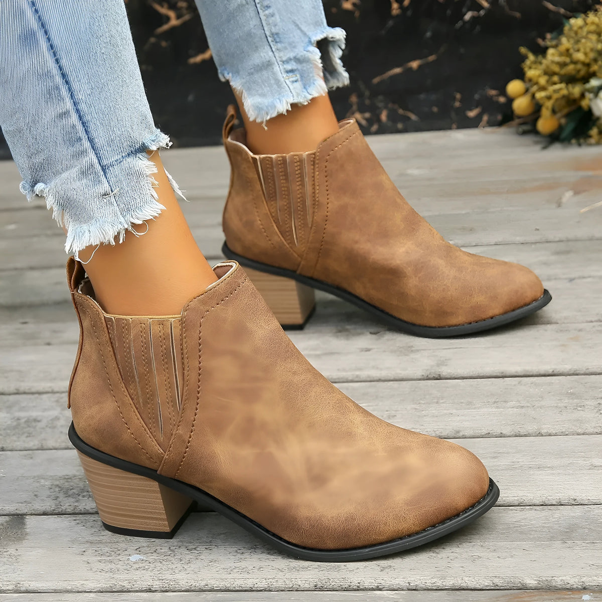 Black women's pointed toe ankle boots with a thick low square heel and slip-on design.