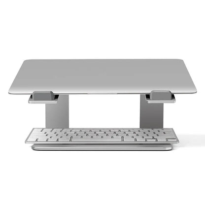 Black aluminium alloy laptop stand on a desk, showing its raised platform and open base design.