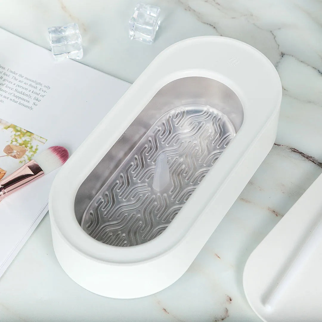 White portable ultrasonic cleaner with stainless steel tank for cleaning jewellery and glasses.