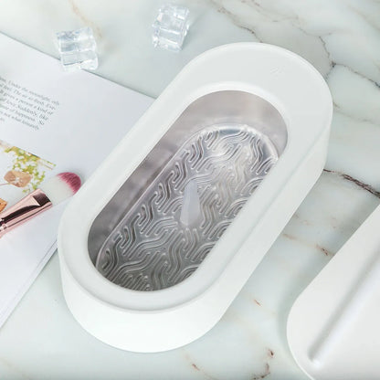 White portable ultrasonic cleaner with stainless steel tank for cleaning jewellery and glasses.