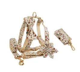 Small white flower decoration on a cloth dog collar and leash set with matching vest and bow.