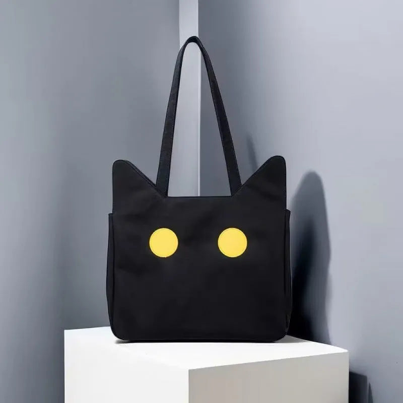 Black cat-shaped nylon tote bag with medium-soft structure, nylon lining, and sandwich zipper pocket, 34cm x 13cm x 27cm.