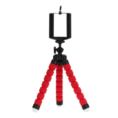 Black flexible octopus tripod with legs wrapped around a pole, holding a smartphone with a clip mount.
