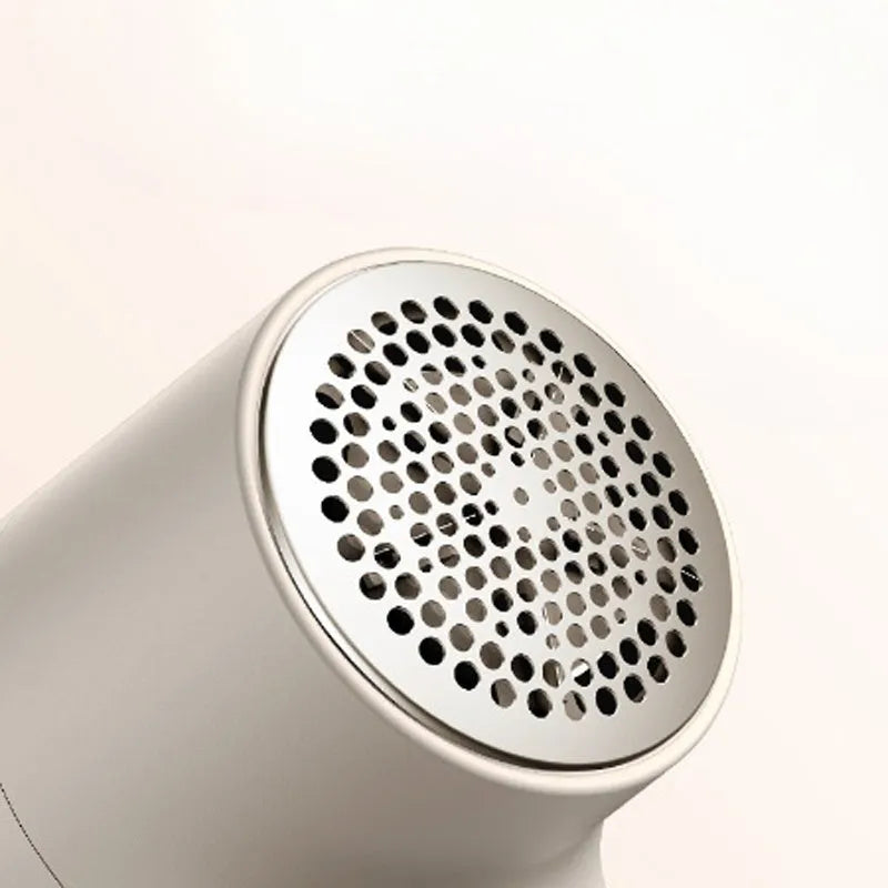White electric lint remover with digital display showing six stainless steel blades and USB charging port
