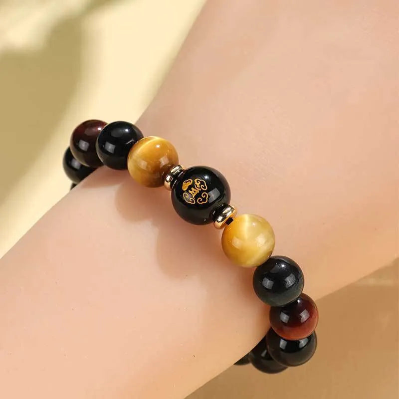 Handcrafted black agate and tiger eye stone beaded bracelet with a central carved zodiac deity charm.