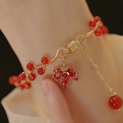 Red ginkgo leaf charm magnetic bracelet for girls on a wrist, showing maple leaf design details.