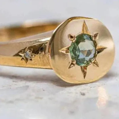 Golden ring with oval asterism zircon, star shape, and adjustable opening on a plain background